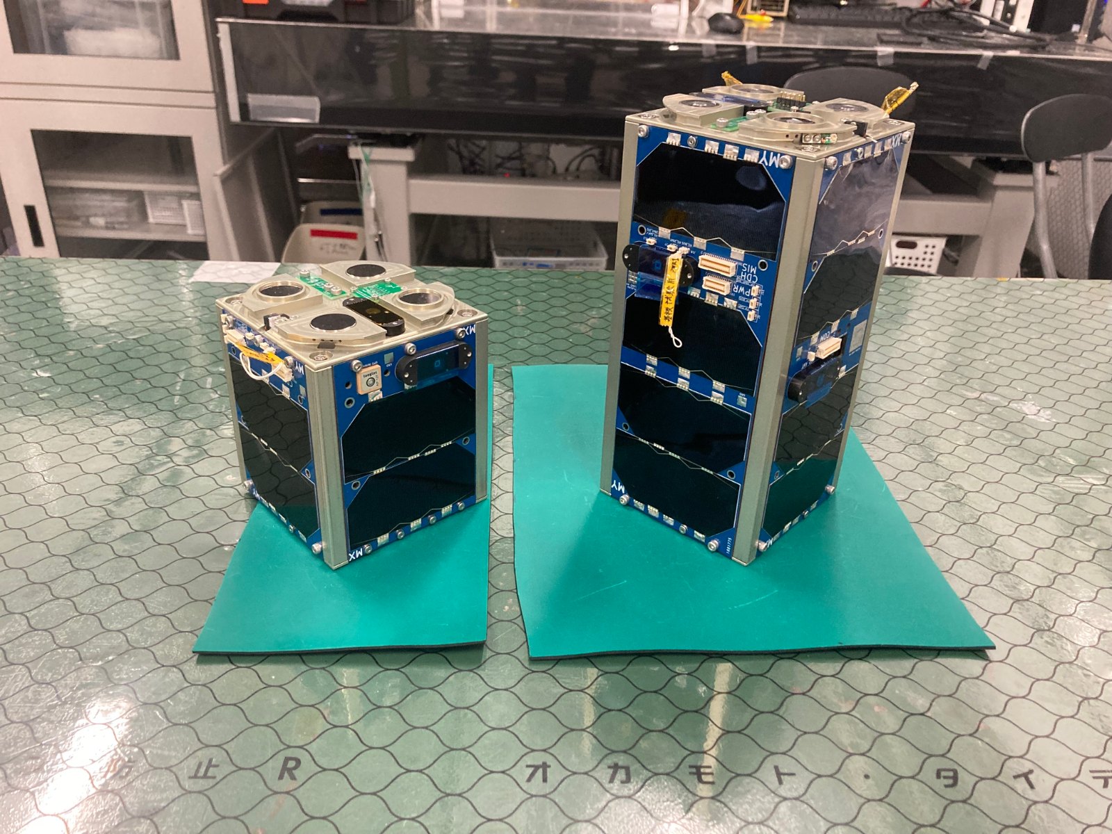 MAGNARO II cube nanosatellite units, docked and separated, on a lab bench