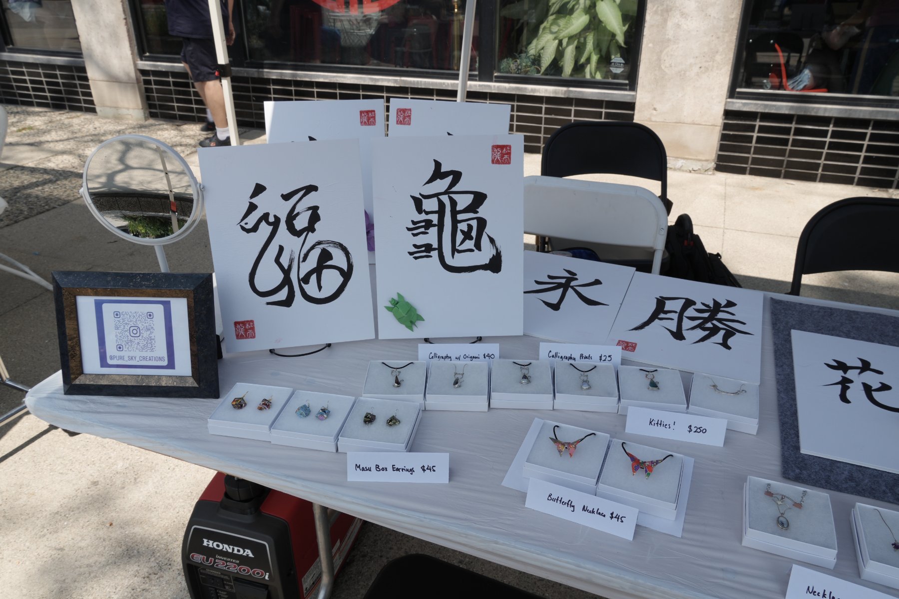 福 and 龜 calligraphy boards with an origami turtle, beside masu box earrings and silver kitten pendants