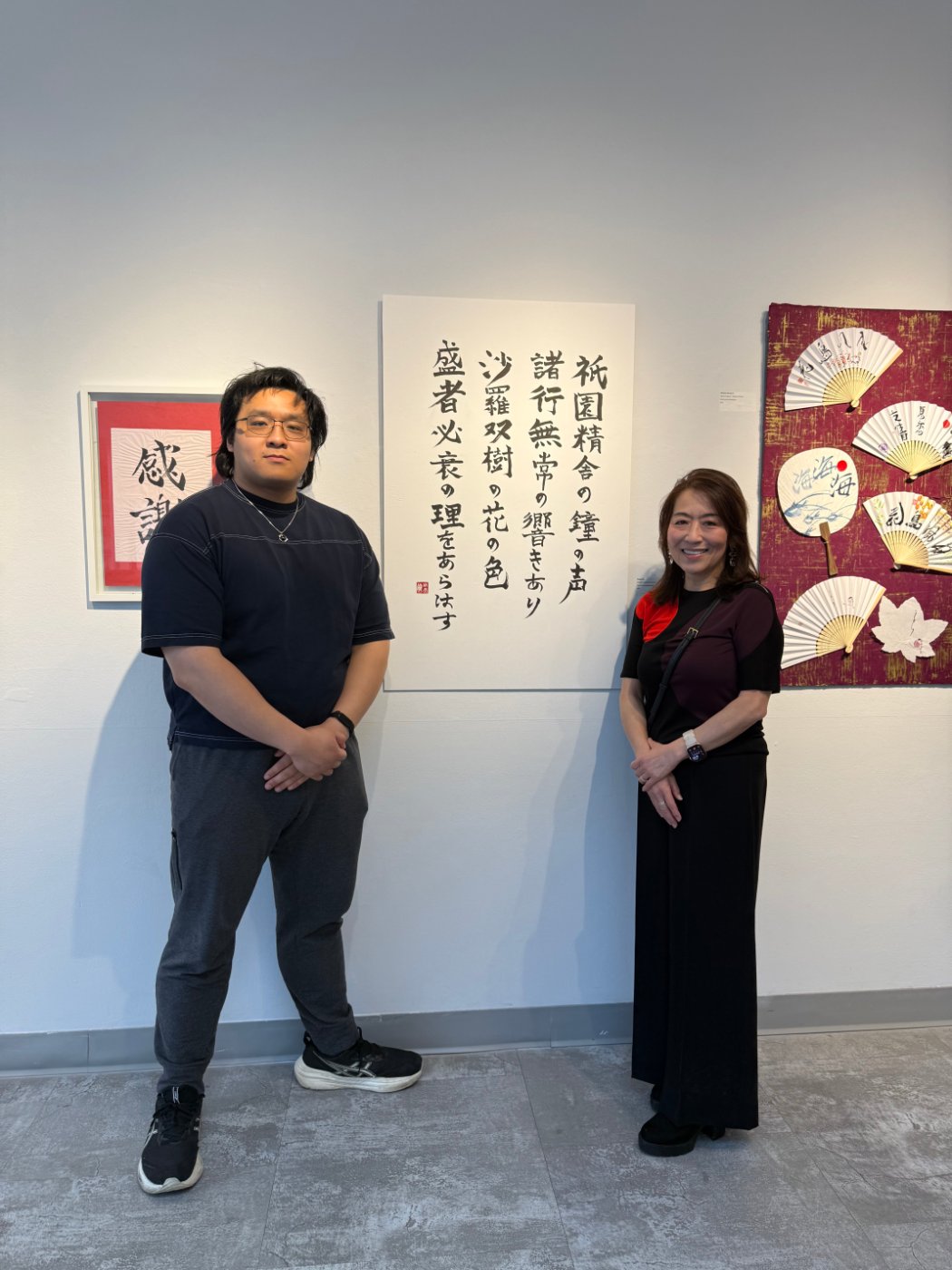 Skyler with Kyoko sensei in front of the framed Heike Monogatari calligraphy at the gallery
