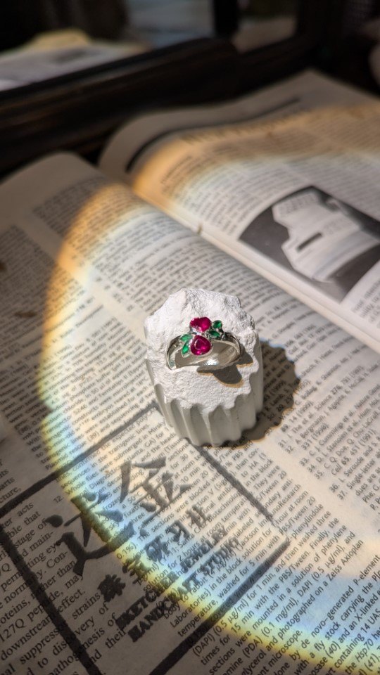 Double Heart Ring: cluster of red and green stones forming blossoms on a silver band