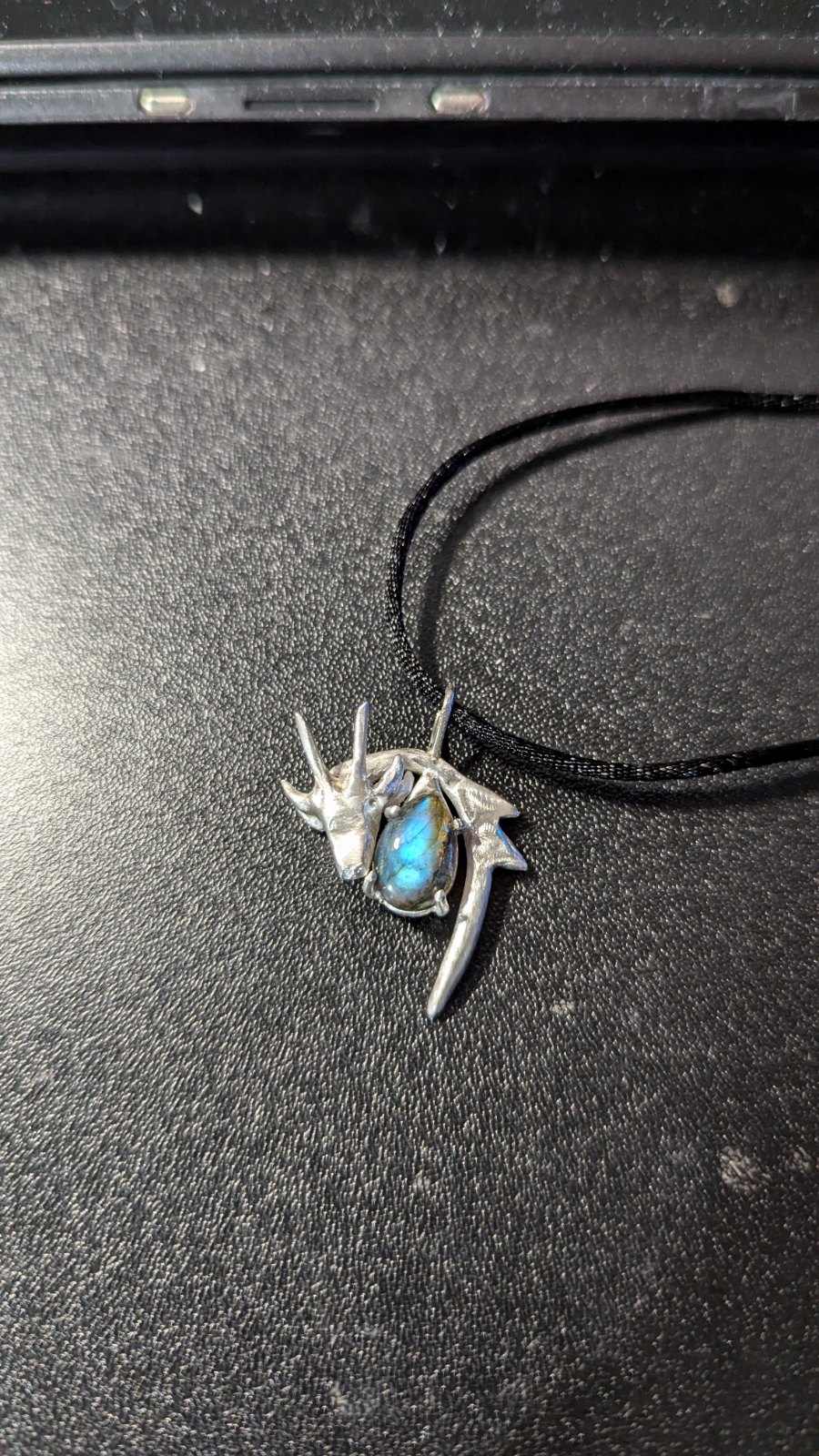 Dragon Necklace: silver dragon head pendant cradling an oval labradorite cabochon on a black cord
