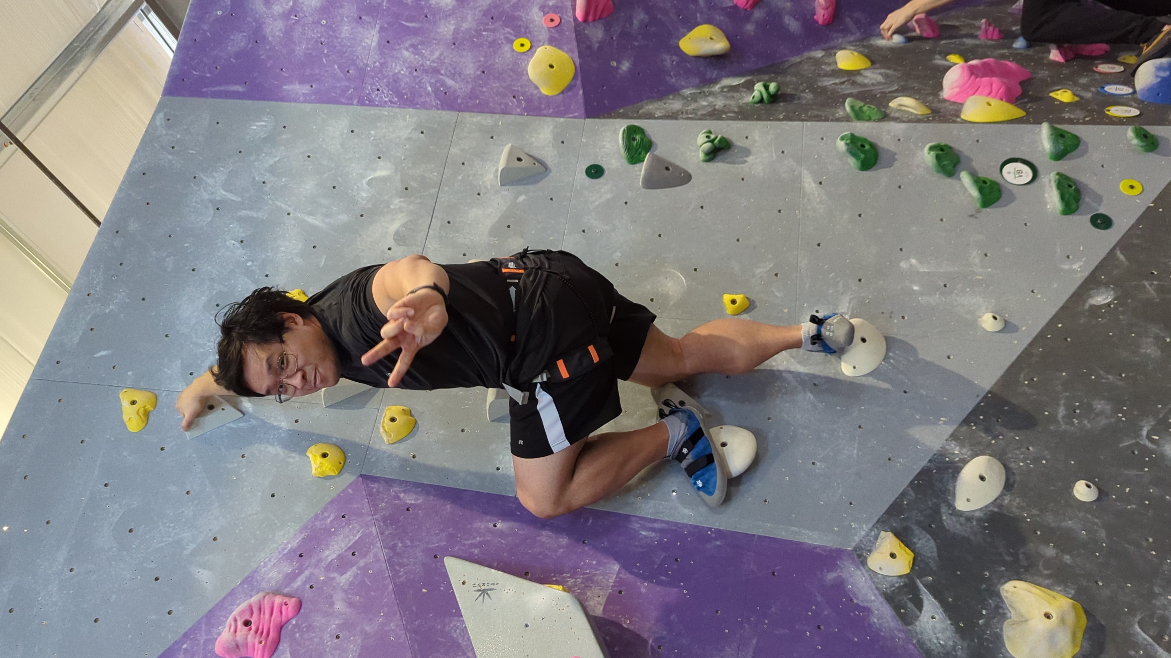 Bouldering on an indoor climbing wall, mid-route