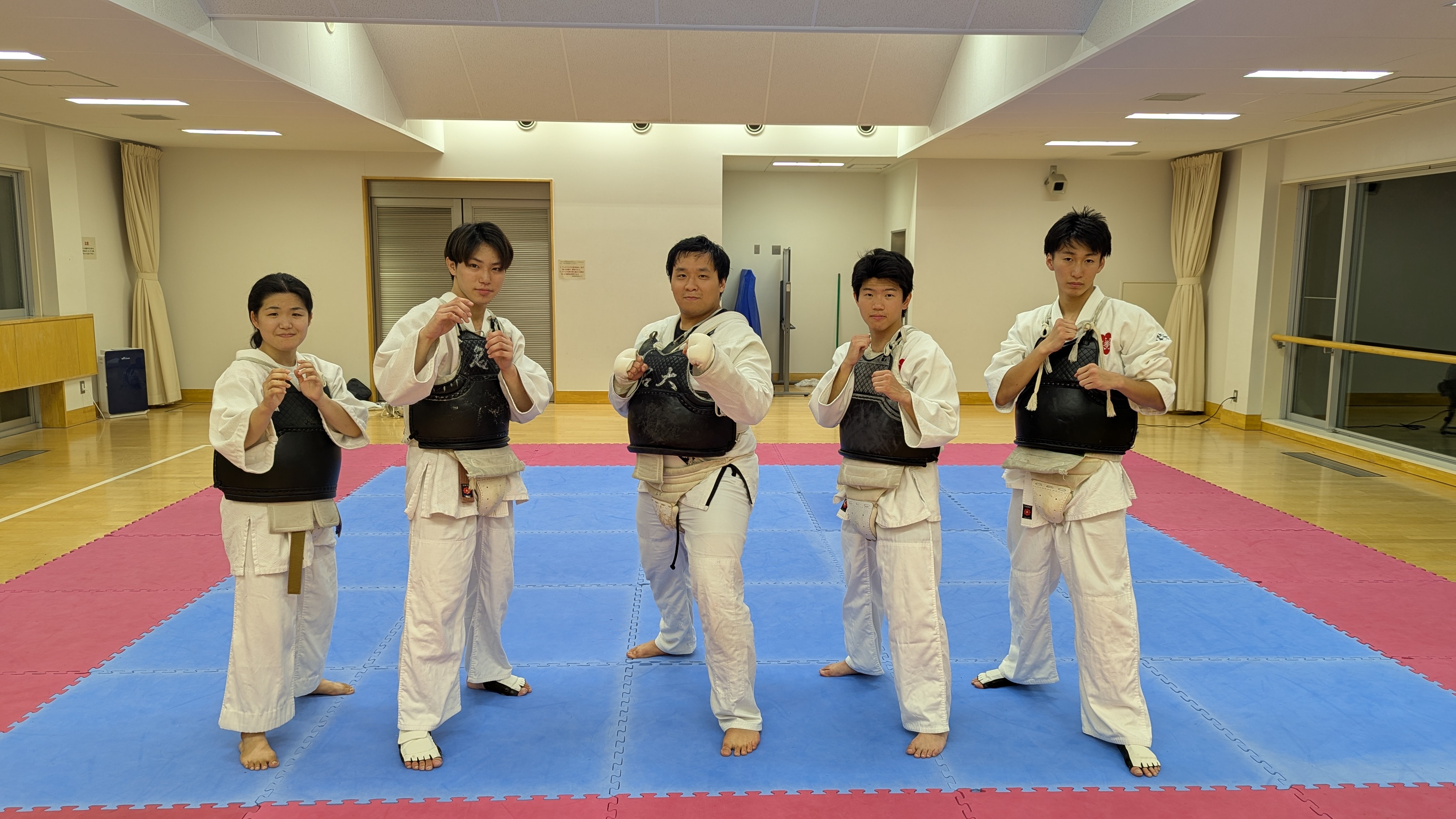 Kenpo group in black gi with sashes lined up in formation on the mat