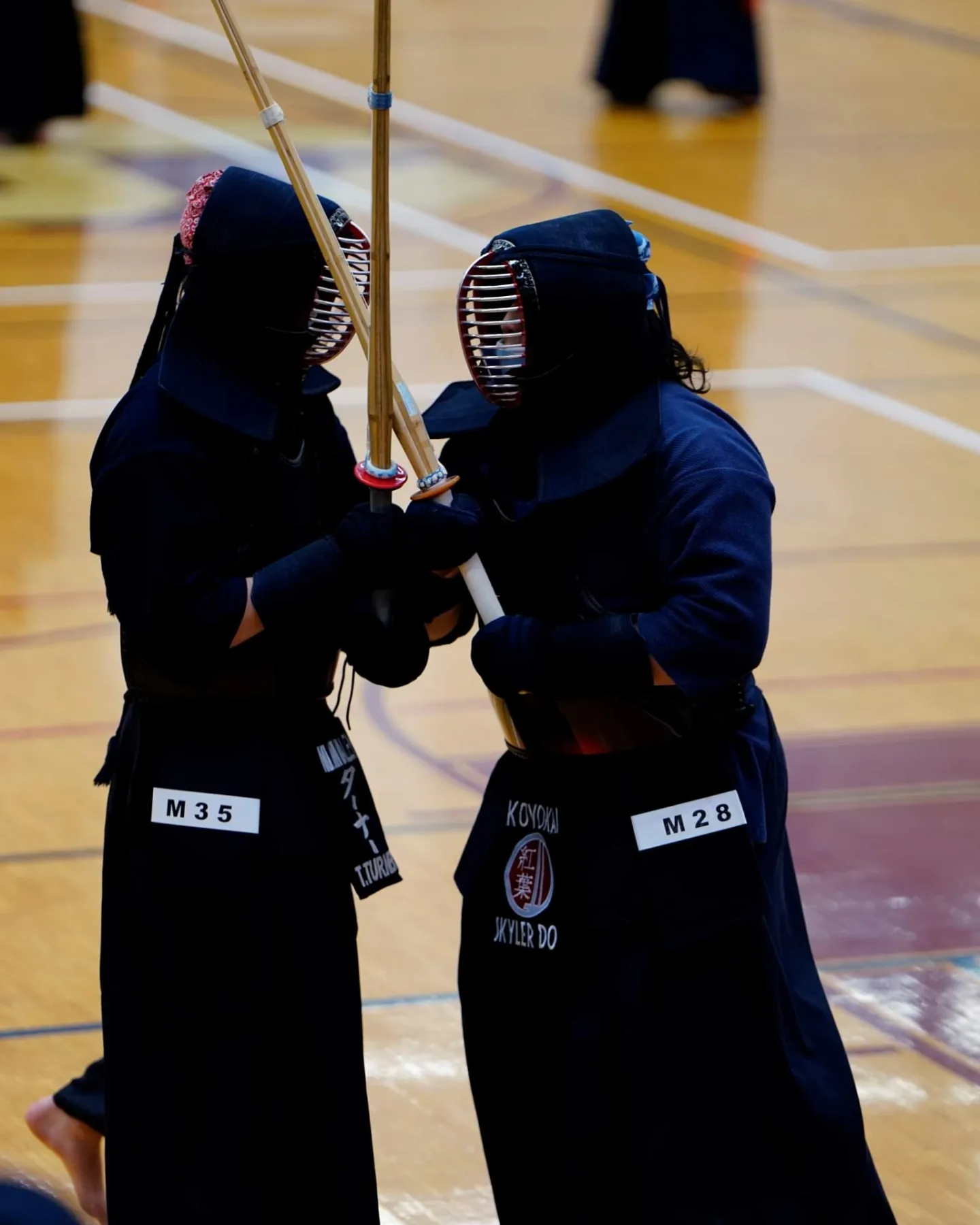 Skyler in a kendo competition bout, bogu armor, shinai crossed at close quarters