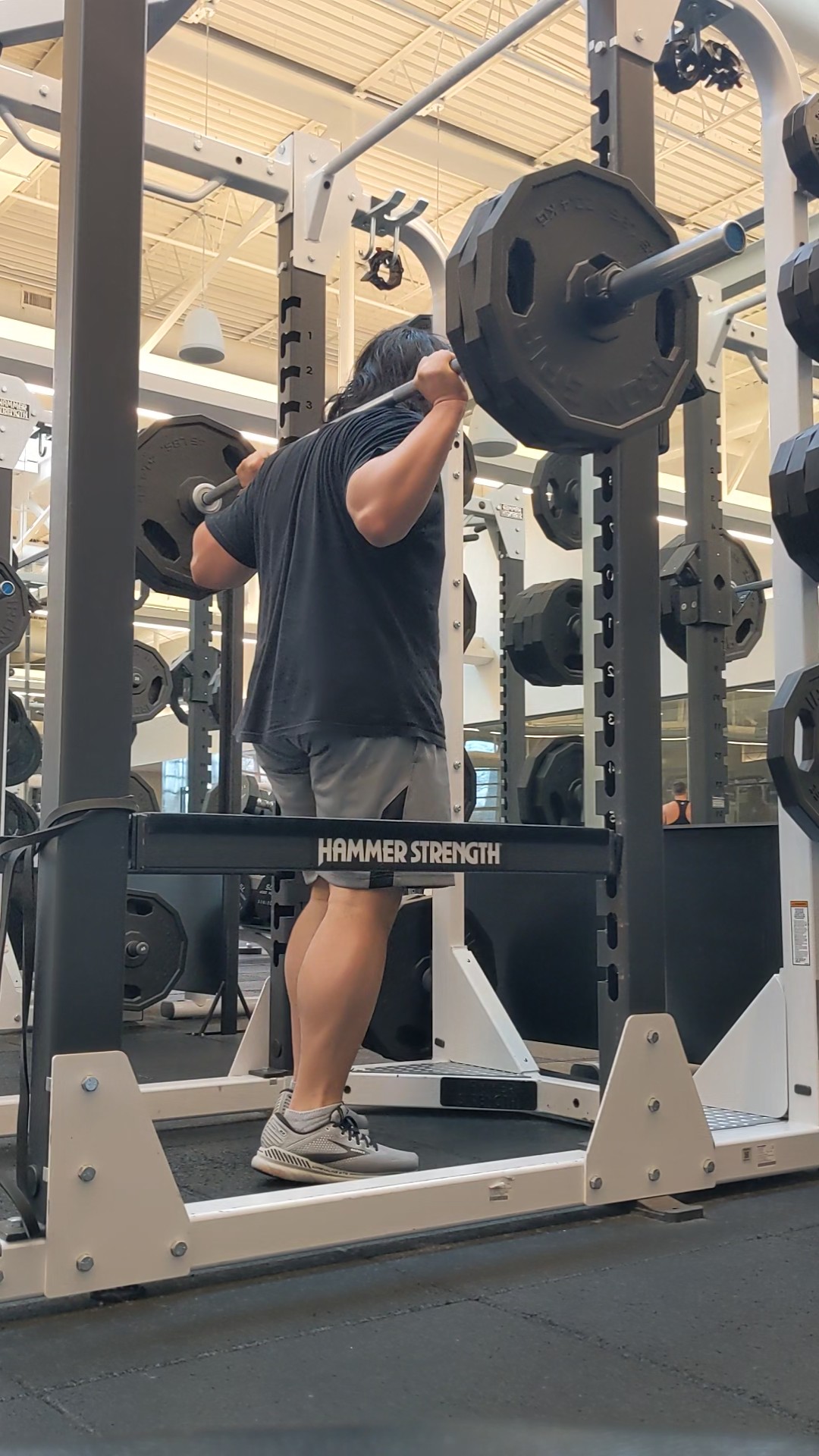 Barbell back squat in a Hammer Strength rack at the gym