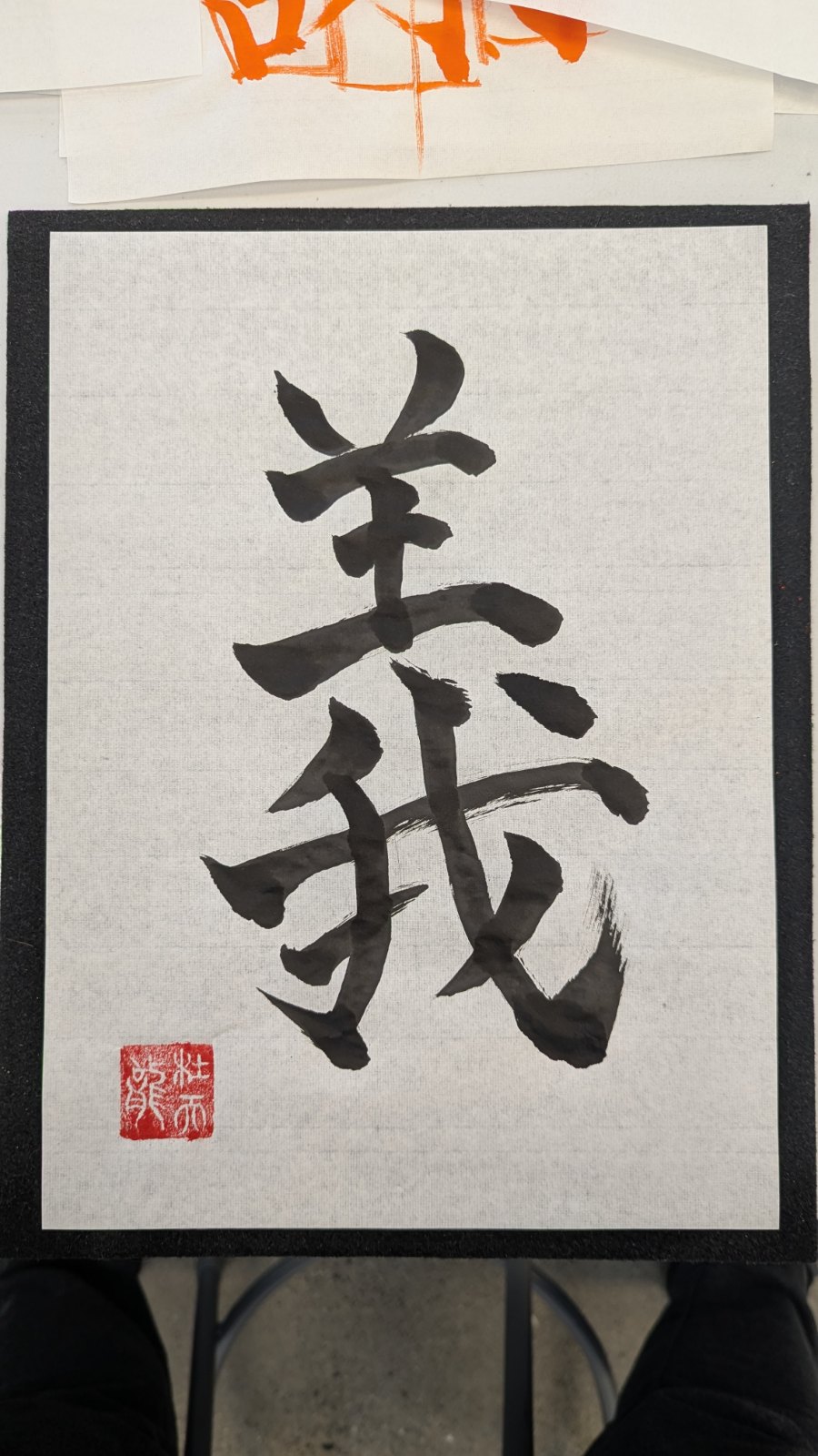 Shodo calligraphy of the kanji 義 (gi, righteousness) in gyosho brushwork with a red seal